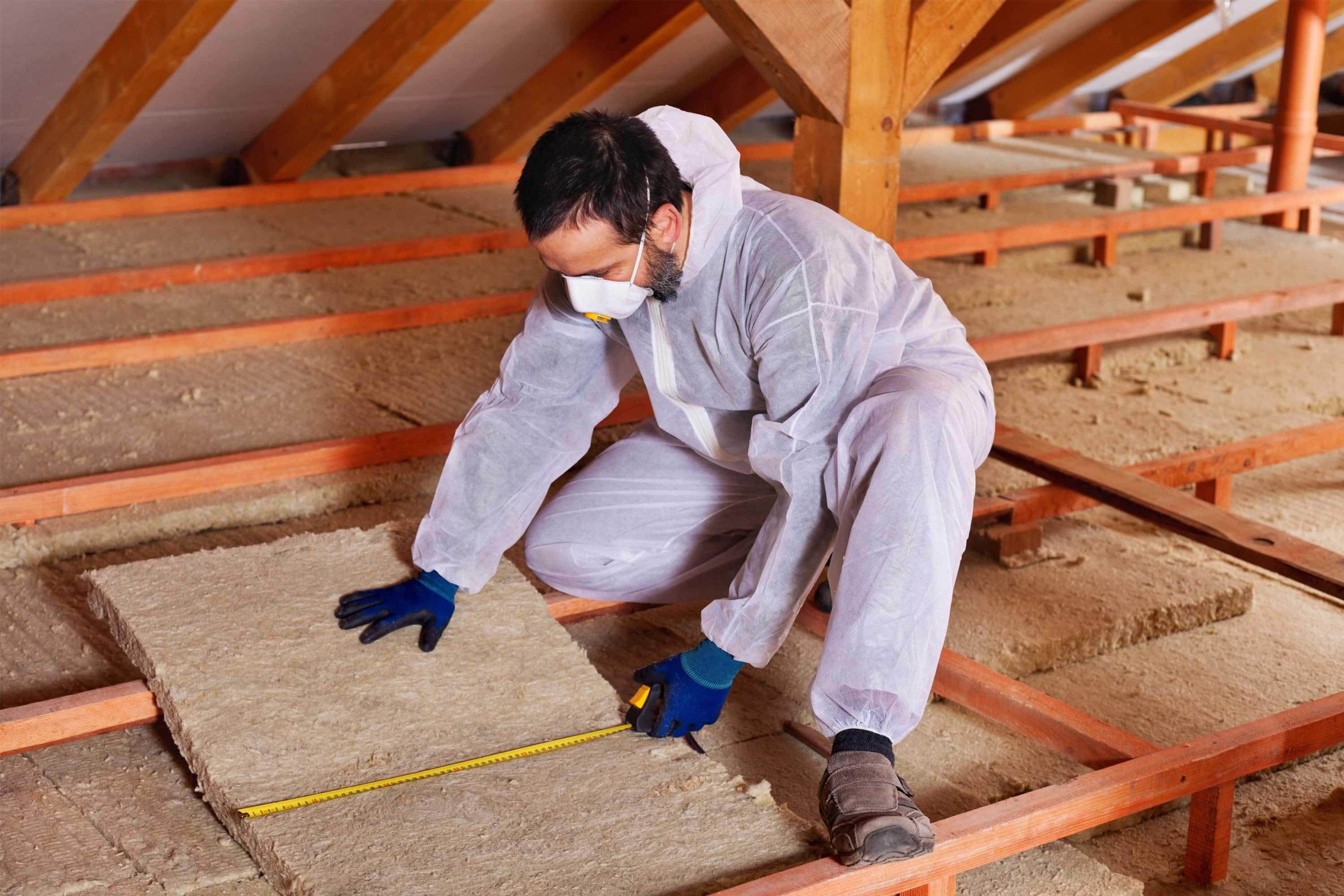 Installateur legt dakisolatie tussen de balken